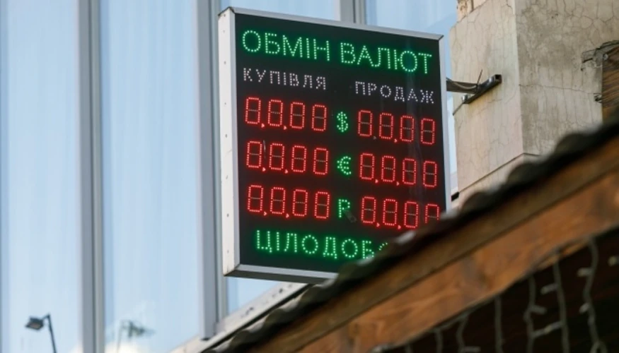 Банкноти долара США та євро на тлі графіка курсу гривні